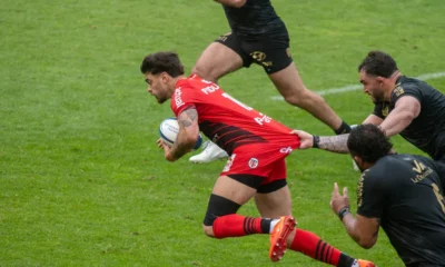Romain Ntamack, ballon en main, retenu par le maillot par un Toulonnais, avec le Stade Toulousain à Toulon en avril 2025