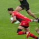Romain Ntamack, ballon en main, retenu par le maillot par un Toulonnais, avec le Stade Toulousain à Toulon en avril 2025