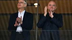 Arsène Wenger et Gianni Infantino applaudissent côte à côte en tribune lors d'un match