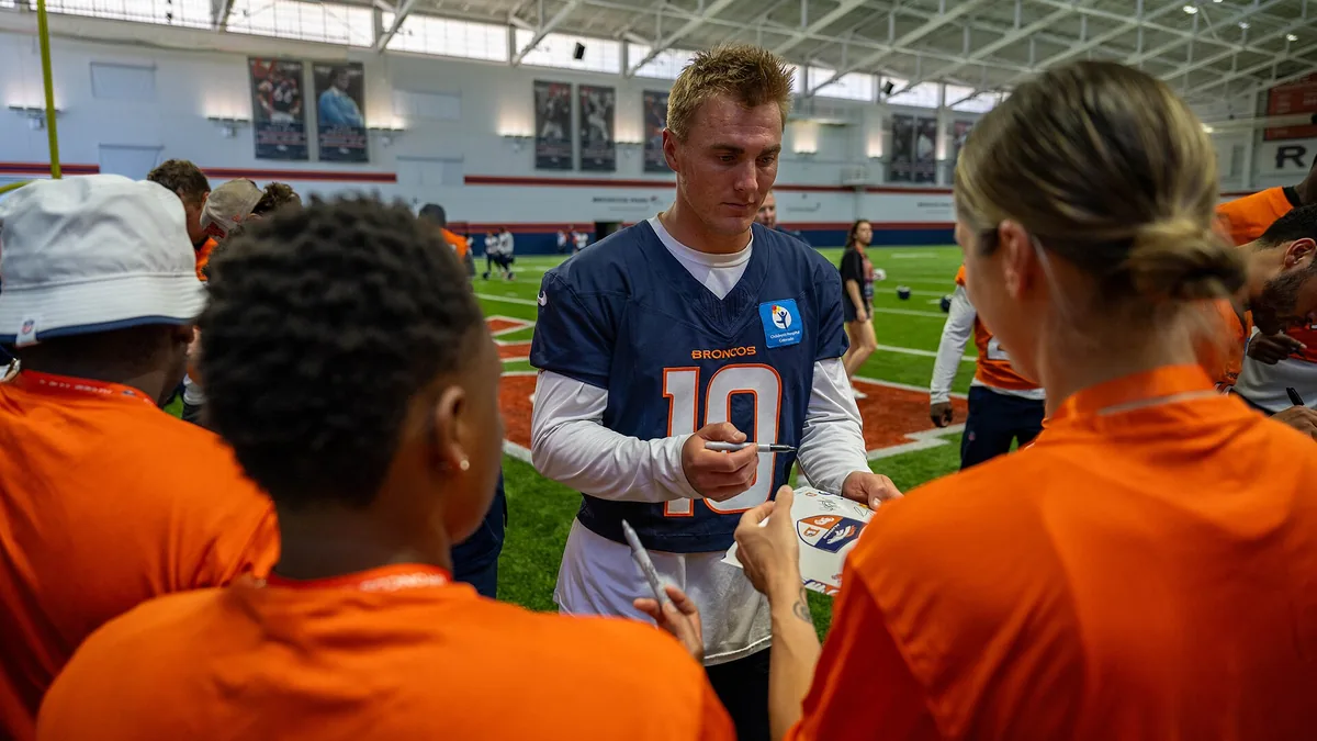 Bo Nix, quarterback des Denver Broncos, signe des autographes au centre d'entraînement du club en août 2025