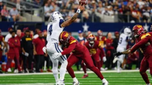 Dak Prescott lance sous la pression d'un défenseur des Commanders à l'AT&T Stadium, octobre 2025