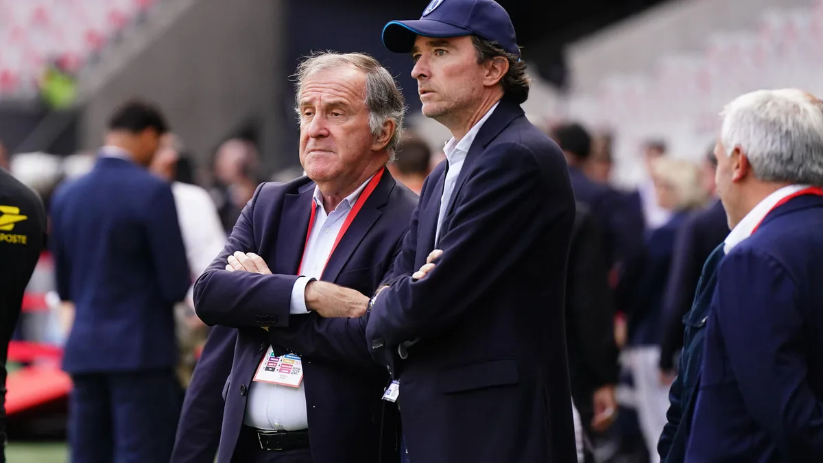Pierre Ferracci et Antoine Arnault, bras croisés au bord de la pelouse avant un match du Paris FC