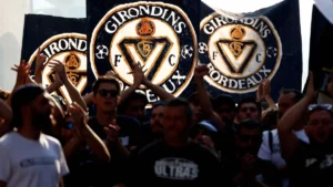 Supporters des Girondins de Bordeaux brandissant des drapeaux au logo du club, saison 2026