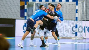 Un joueur du HBC Nantes en maillot noir pris par la défense de Plock, Ligue des champions, octobre 2026