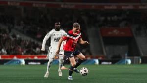 Un joueur du LOSC conduit le ballon devant Mama Baldé lors de Lille-Brest en Ligue 1, octobre 2026