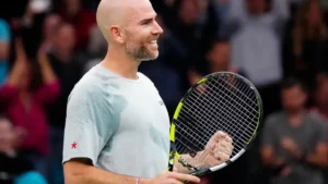 Adrian Mannarino souriant, raquette en main, après un point gagné lors d'un tournoi en salle