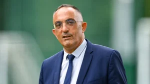 Mohamed Sanhadji, responsable de la sécurité de l'équipe de France, en costume au bord d'un terrain