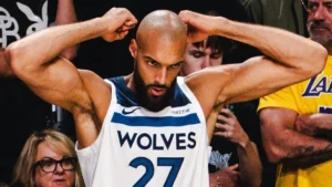 Rudy Gobert sous le maillot blanc des Minnesota Timberwolves, bras levés pendant un match