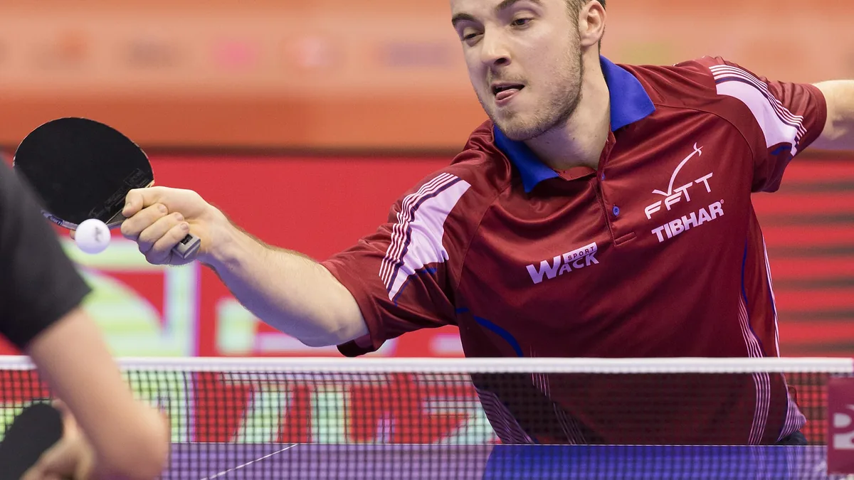 Simon Gauzy en coup droit sous le maillot de l'équipe de France aux Mondiaux par équipes 2016