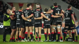 Les joueurs du Stade Toulousain réunis en cercle sur la pelouse pendant un match