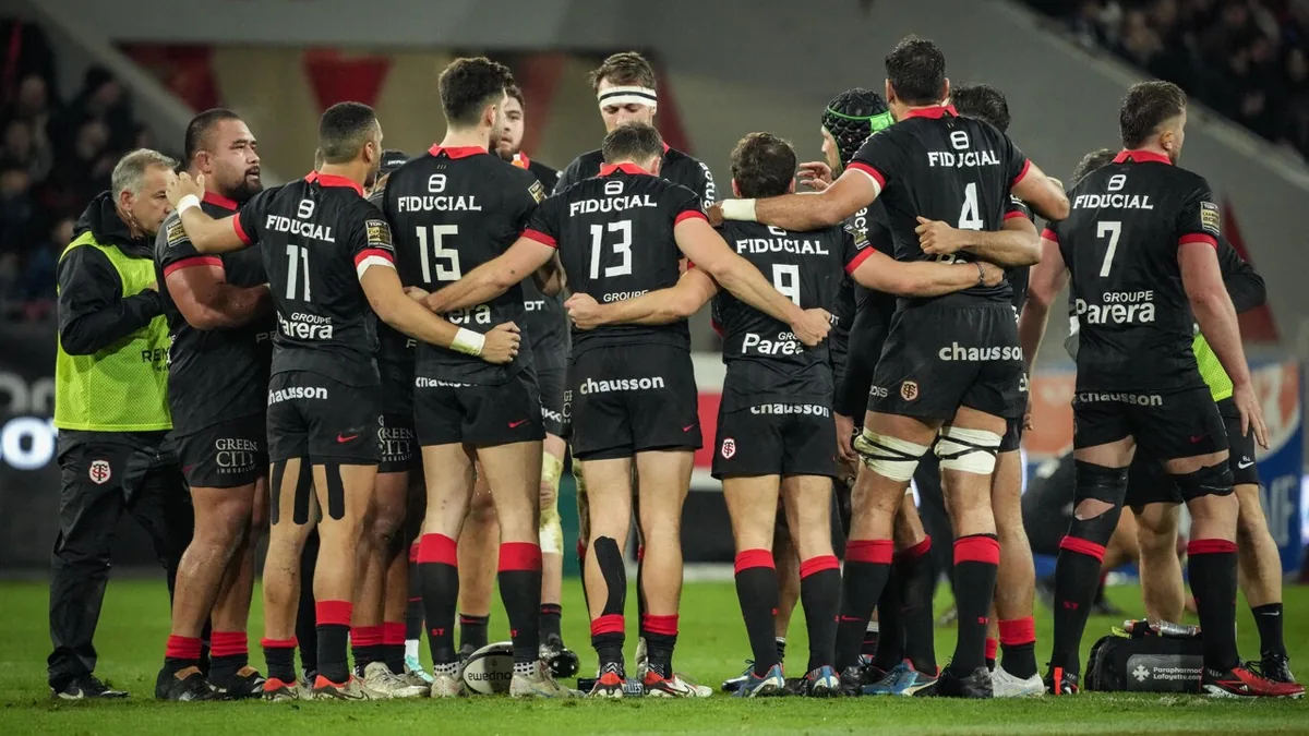 Les joueurs du Stade Toulousain réunis en cercle sur la pelouse pendant un match