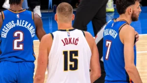 Nikola Jokic entre Shai Gilgeous-Alexander et Chet Holmgren lors d'un match Thunder-Nuggets à Oklahoma City