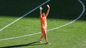 Unai Simón, gardien de l'Espagne, lève les bras sur la pelouse lors d'un match de la Roja