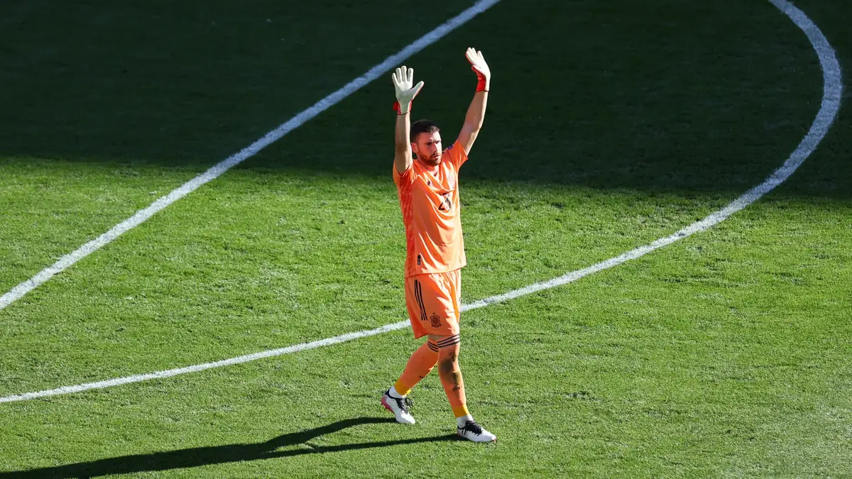 Unai Simón, gardien de l'Espagne, lève les bras sur la pelouse lors d'un match de la Roja