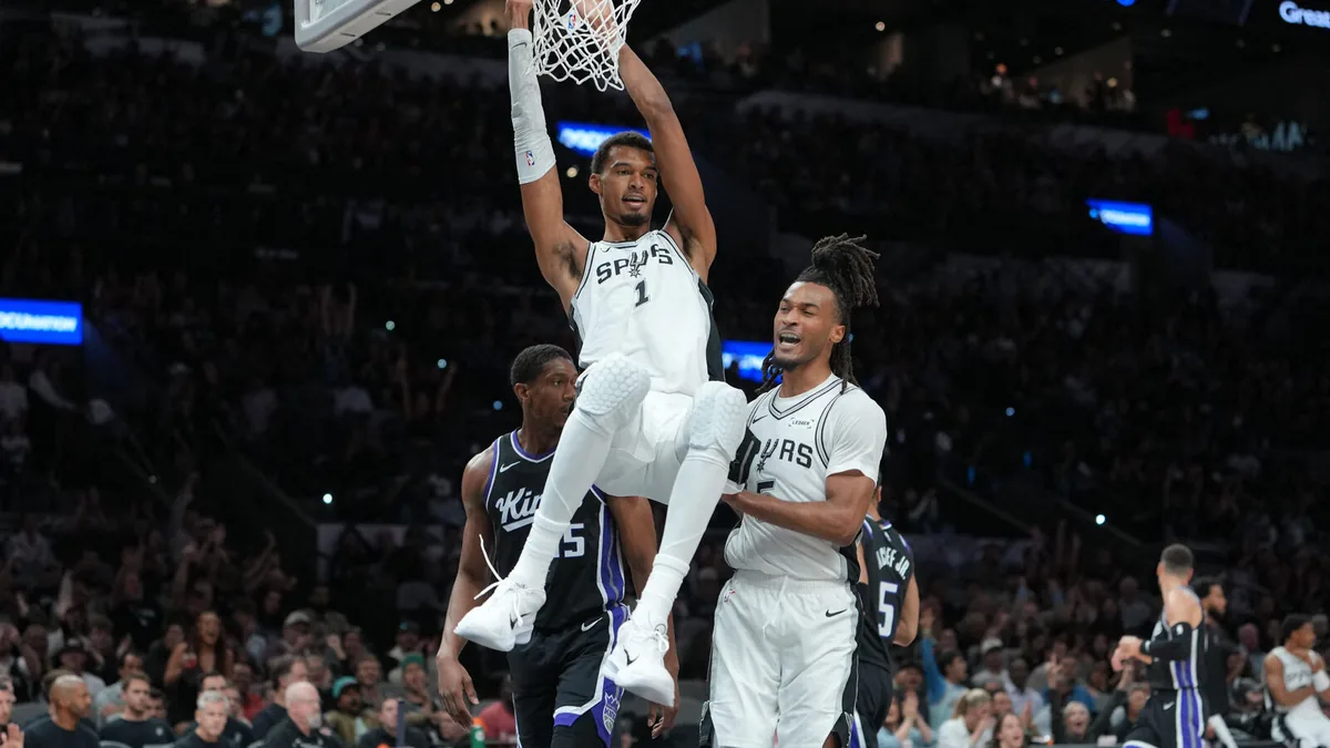 Victor Wembanyama accroché au cercle après un dunk avec les Spurs face aux Sacramento Kings, octobre 2026